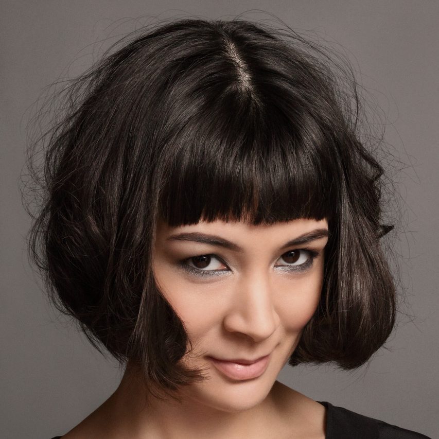 Short bob haircut around chin length on female with straight across bangs